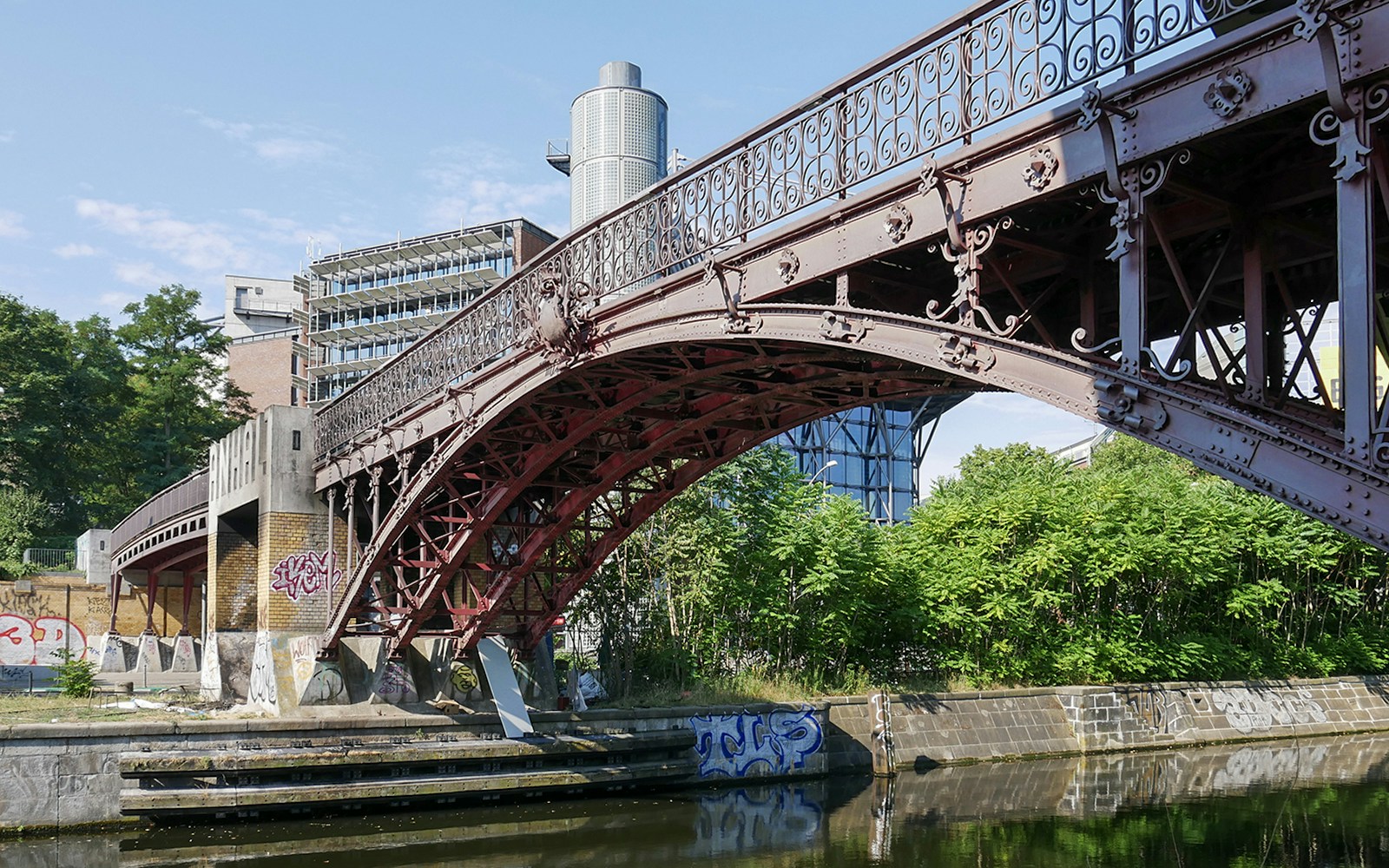 Anhalter Steg bridge over Landwehr Canal in Berlin with surrounding greenery.