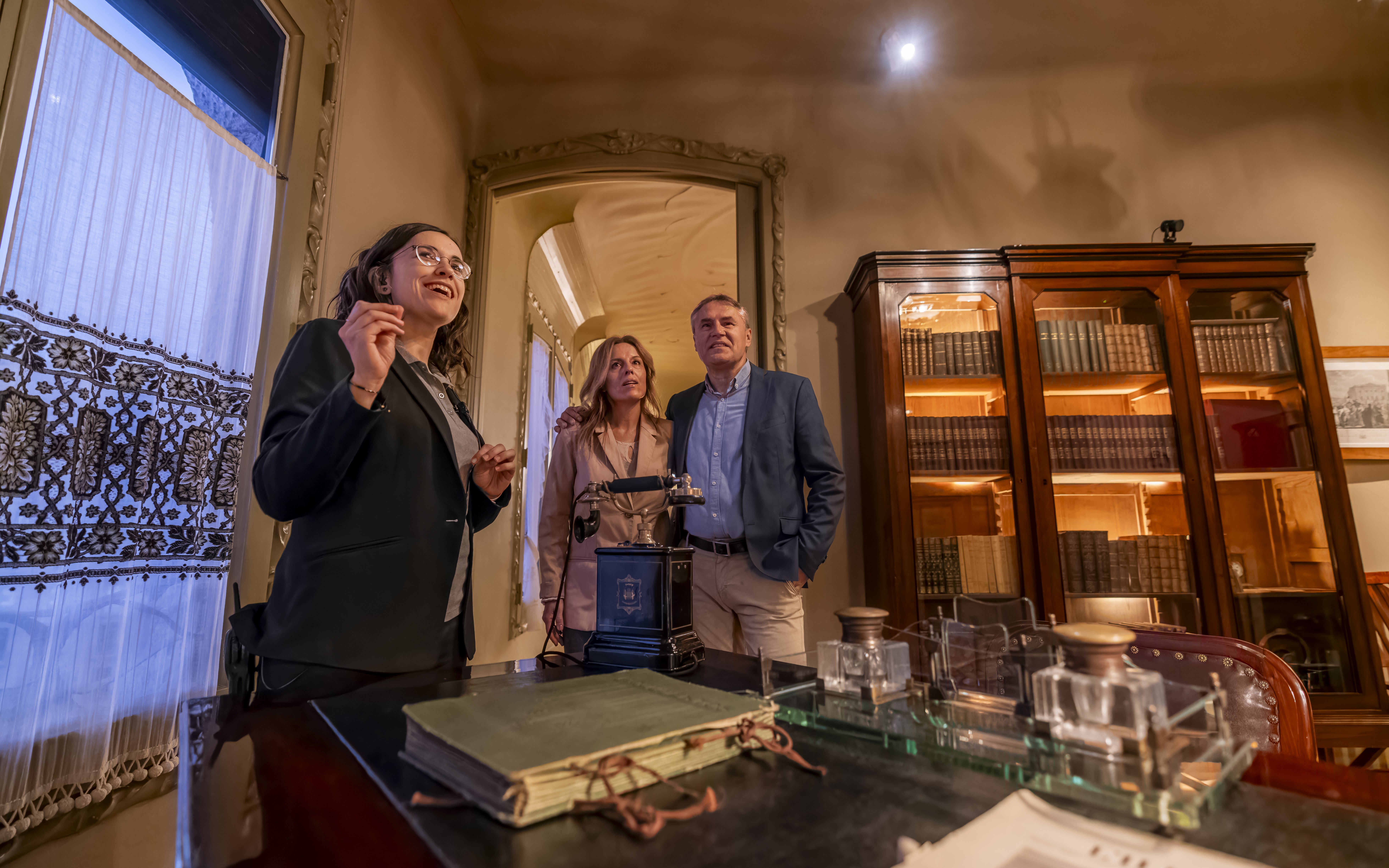Tourist with guide examining artifacts inside Casa Mila, Barcelona.