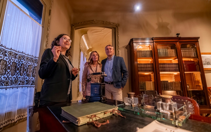 Tourist with guide examining artifacts inside Casa Mila, Barcelona.