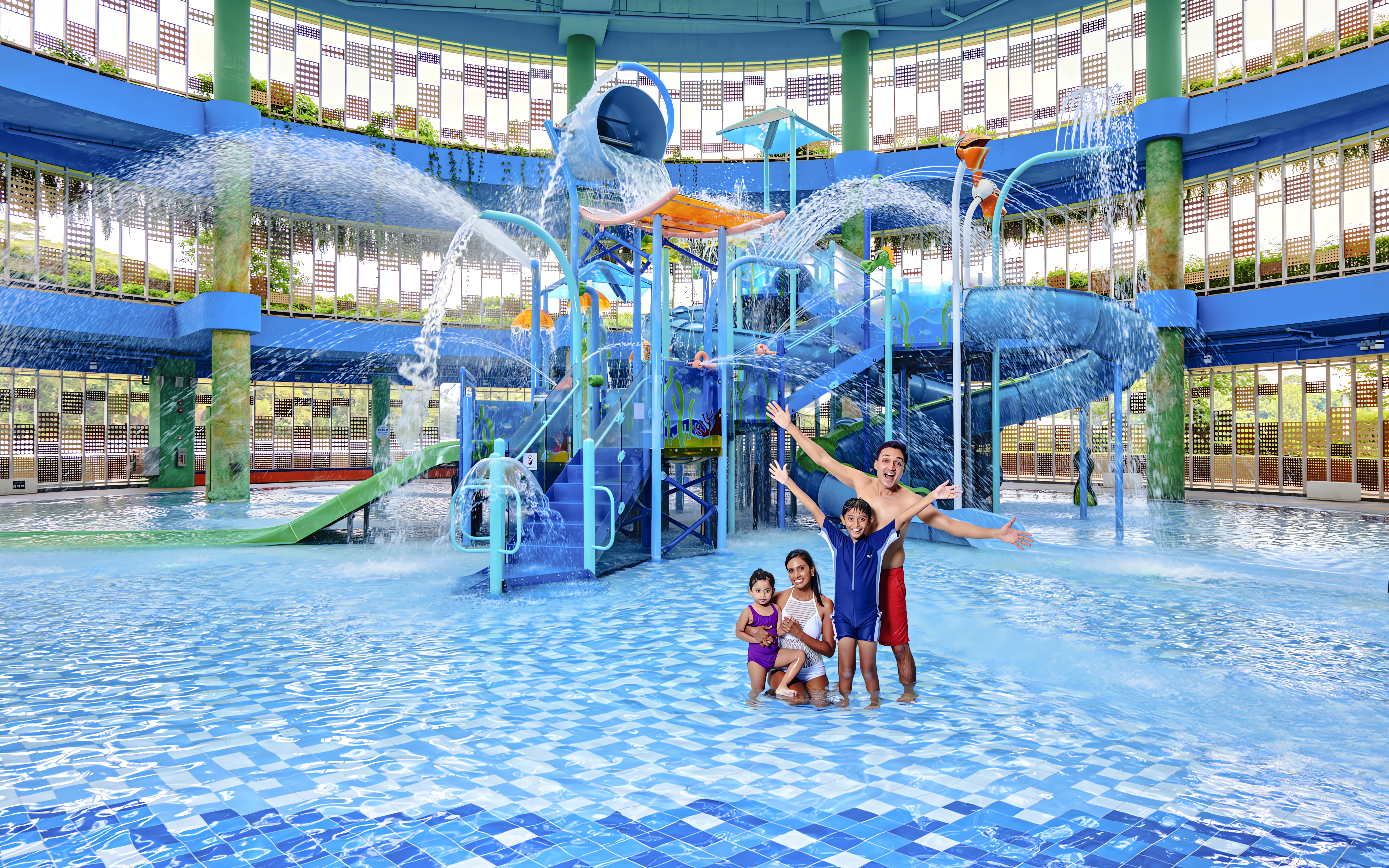 Family enjoying water park with slides and fountains in Singapore.