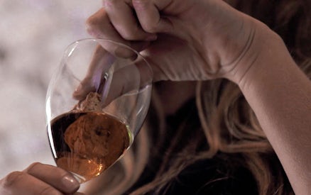 Wine expert examining a glass of Super Tuscan wine during a masterclass.