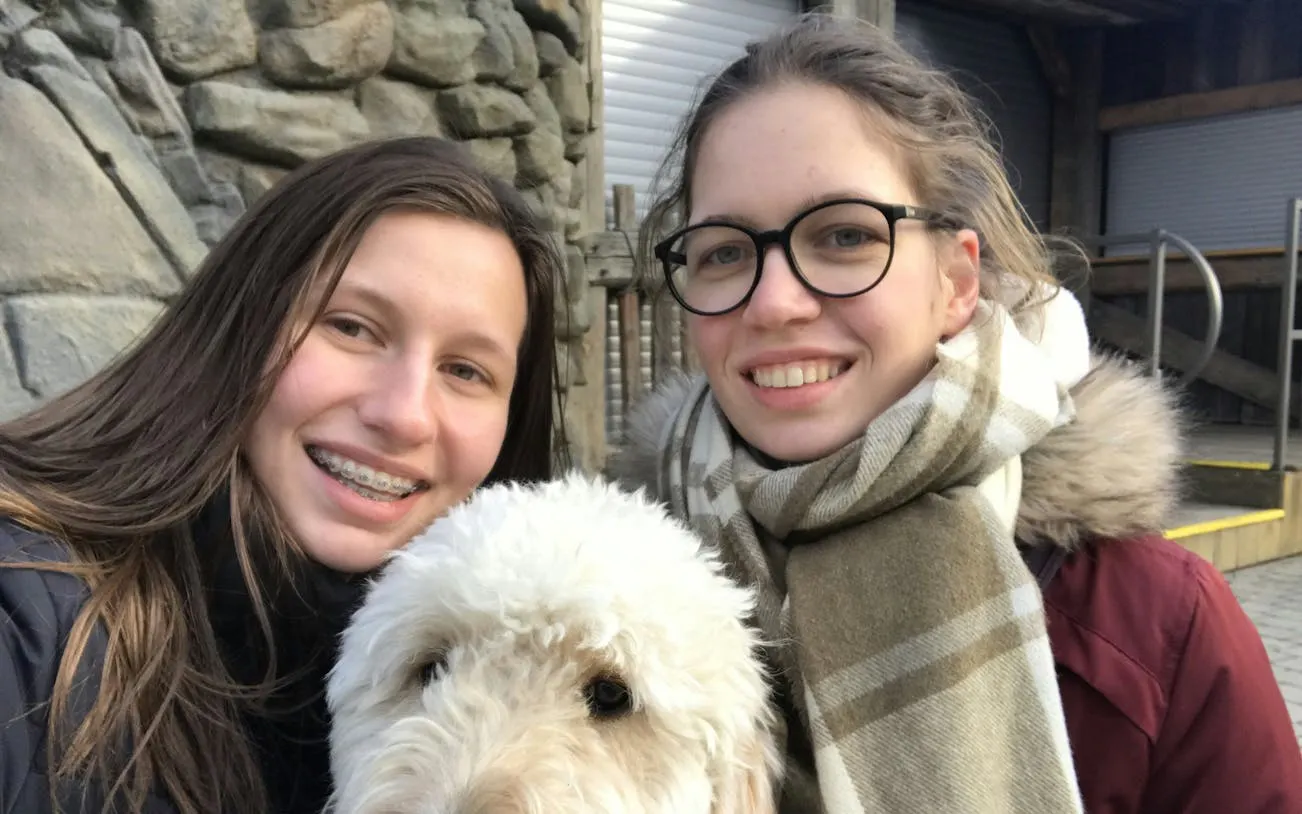 Two people smiling with a dog at Vienna Prater during a self-guided city exploration game.
