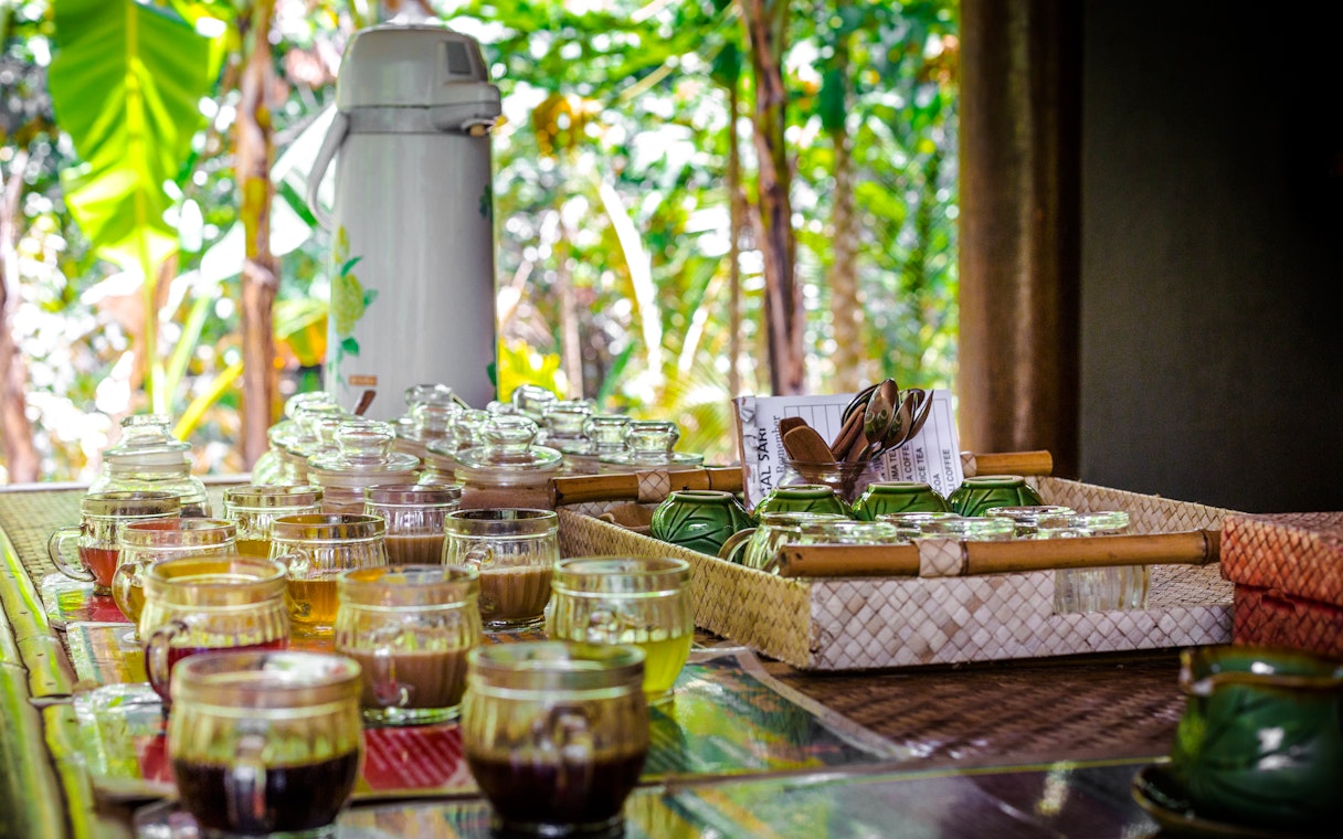Coffee tasting setup with various brews in glass cups on a table in Bali.