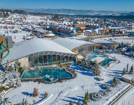 Aerial view of Terma Bania's snow-covered exterior and pools in Krakow.