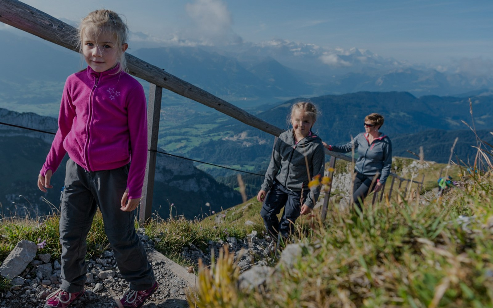 Family hiking on Mount Pilatus trail with scenic views, Lucerne.