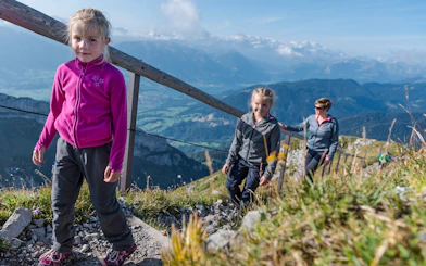 Family hiking on Mount Pilatus trail with scenic views, Lucerne.
