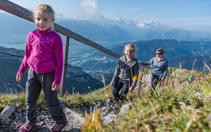 Family hiking on Mount Pilatus trail with scenic views, Lucerne.