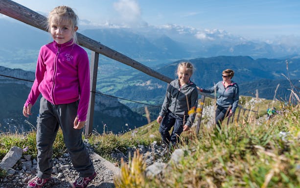 Family hiking on Mount Pilatus trail with scenic views, Lucerne.