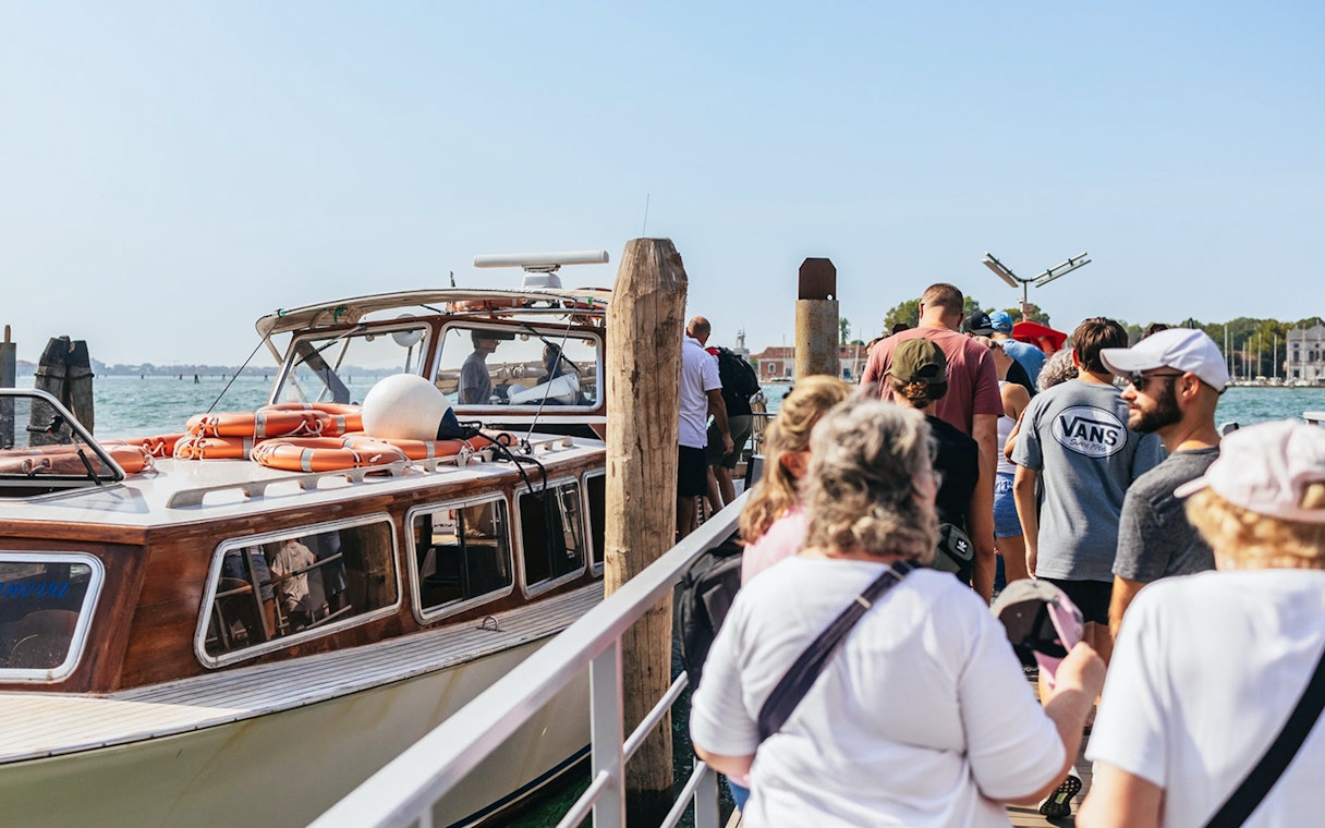Tourists boarding a boat for Murano Burano Islands private tour.
