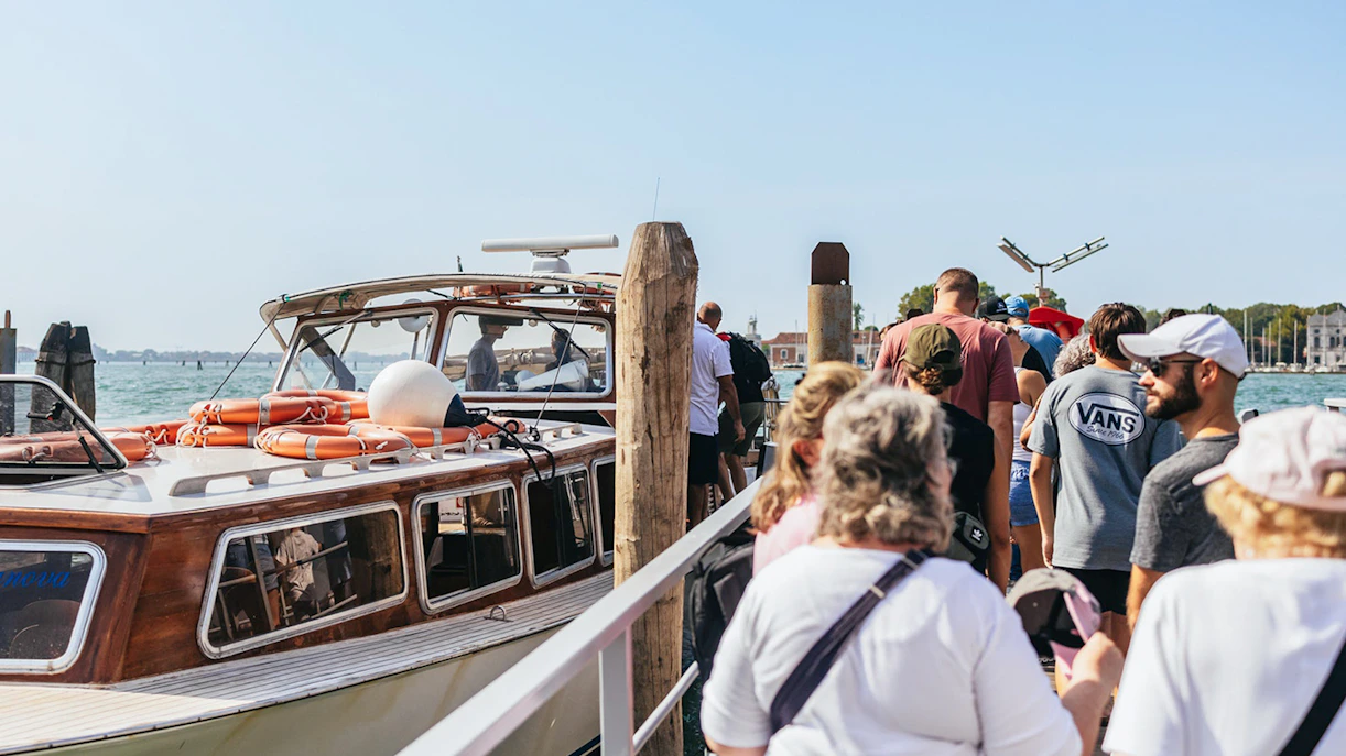 Tourists boarding a boat for Murano Burano Islands private tour.