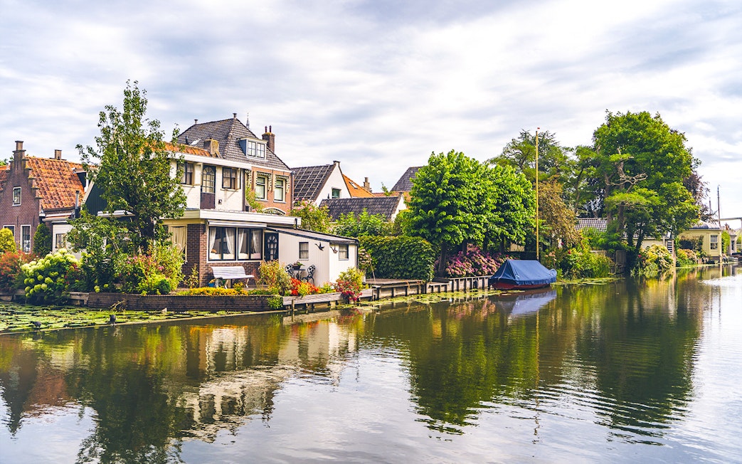 Canal houses and boat along a tranquil waterway in Edam.