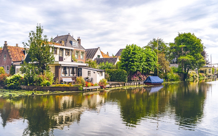 Canal houses and boat along a tranquil waterway in Edam.
