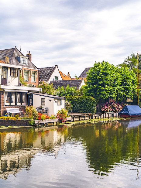 Canal houses and boat along a tranquil waterway in Edam.