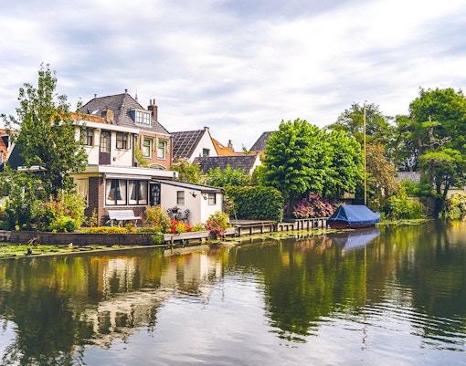 Canal houses and boat along a tranquil waterway in Edam.