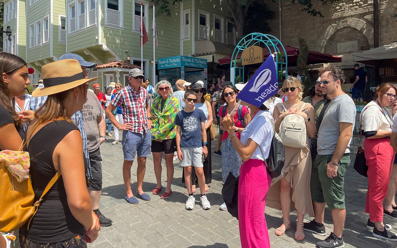 Tour group listening to a guide at Topkapi Palace entrance, Istanbul.
