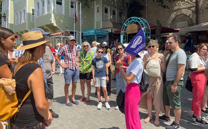 Tour group listening to a guide at Topkapi Palace entrance, Istanbul.