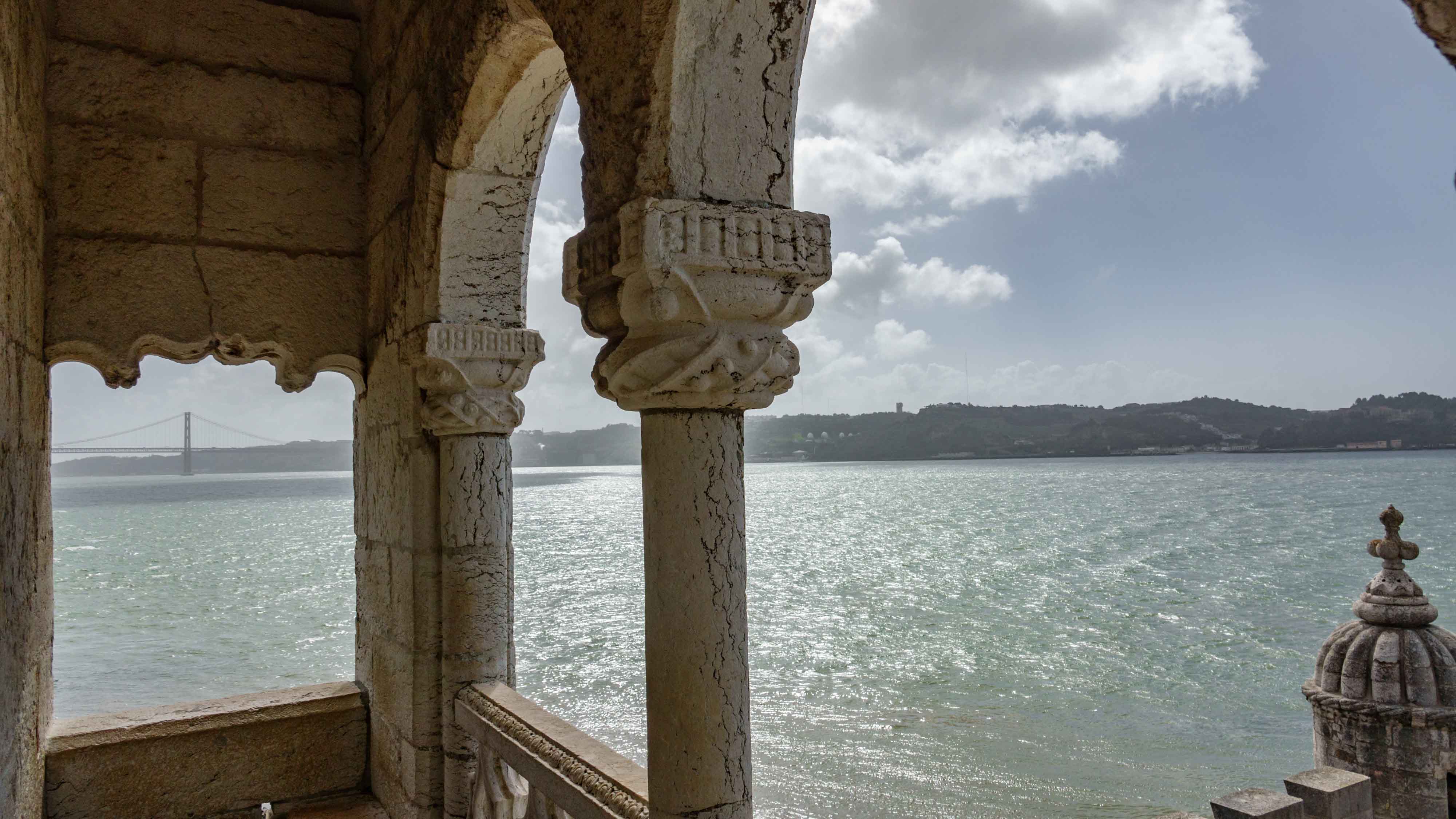 View from Belem Tower overlooking the Tagus River and distant bridge in Lisbon, Portugal.