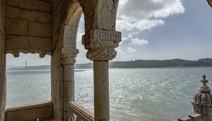 View from Belem Tower overlooking the Tagus River and distant bridge in Lisbon, Portugal.
