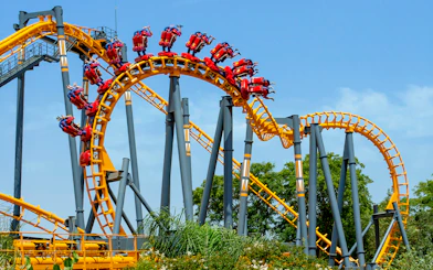 Isla Mágica roller coaster with riders on a loop against a clear sky.