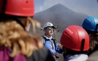 Guide leading a group on Mount Etna summit hike, Sicily.