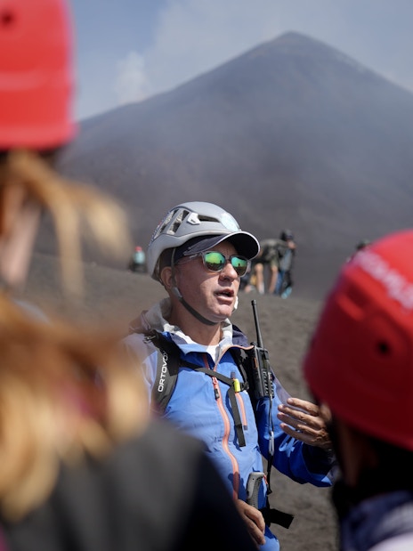 Guide leading a group on Mount Etna summit hike, Sicily.