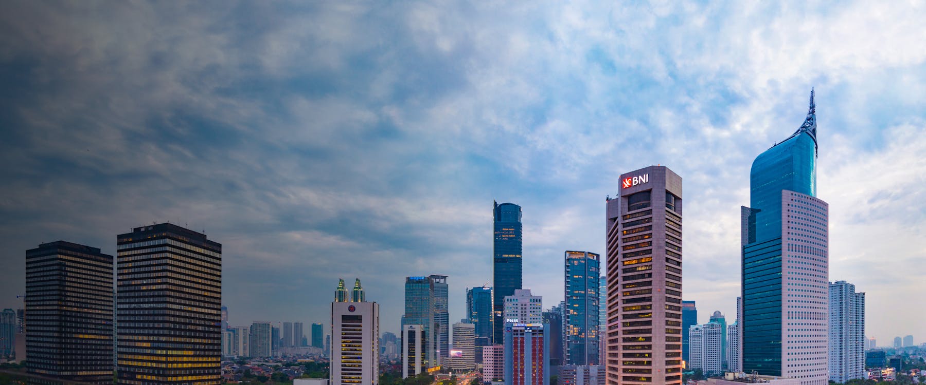 Jakarta skyline with modern skyscrapers under a cloudy sky, Indonesia.
