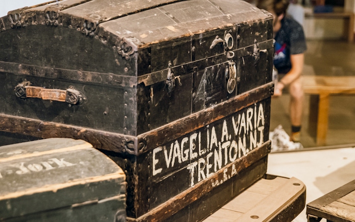 Historic immigrant trunk at Ellis Island Museum, part of Statue of Liberty tour.