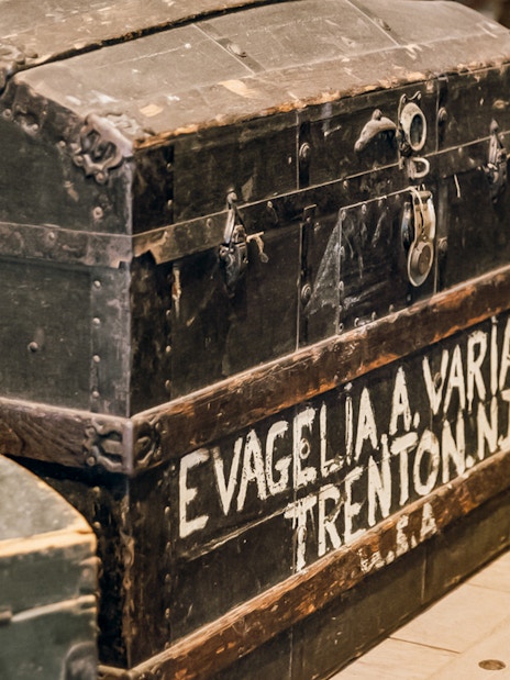 Historic immigrant trunk at Ellis Island Museum, part of Statue of Liberty tour.