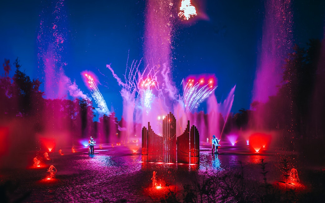 Light show with colorful fountains and fireworks at Puy du Fou, France.