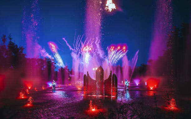 Light show with colorful fountains and fireworks at Puy du Fou, France.