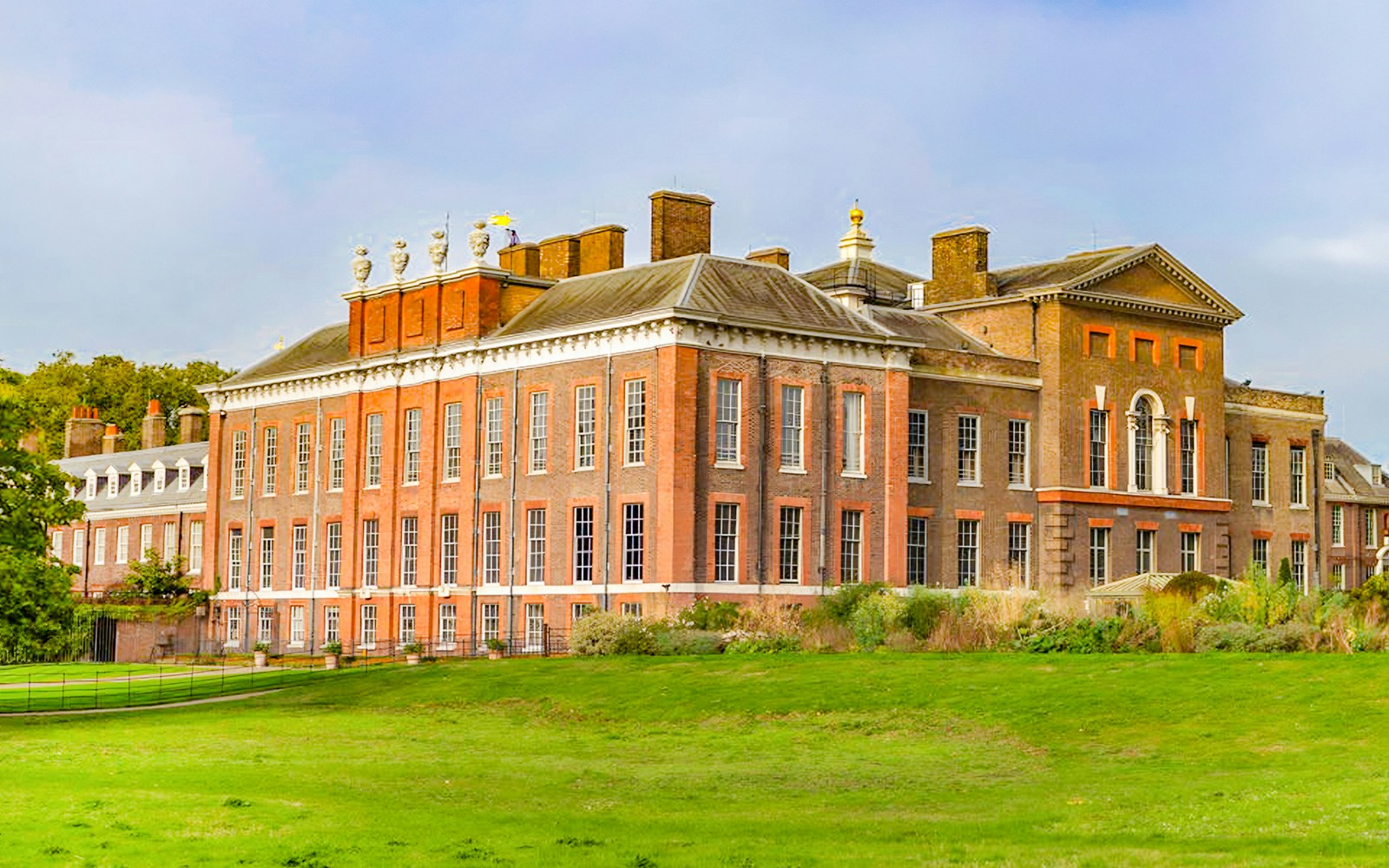 Kensington Palace gardens with tourists exploring the historic site in London.