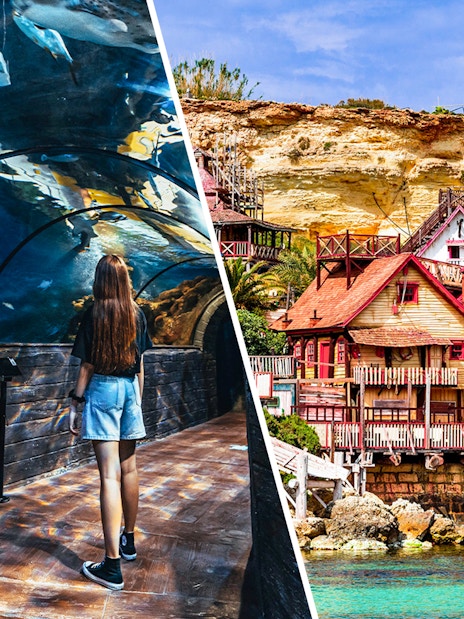 Visitor in Malta National Aquarium tunnel and colorful buildings of Popeye Village.