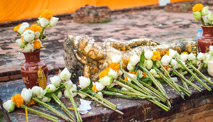 Reclining Buddha statue with flowers at Wat Lokayasutharam, Ayutthaya.