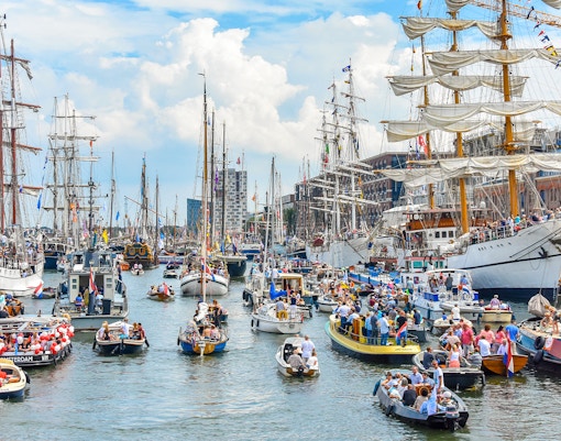Tall ships sailing in Amsterdam harbor during SAIL Amsterdam event.