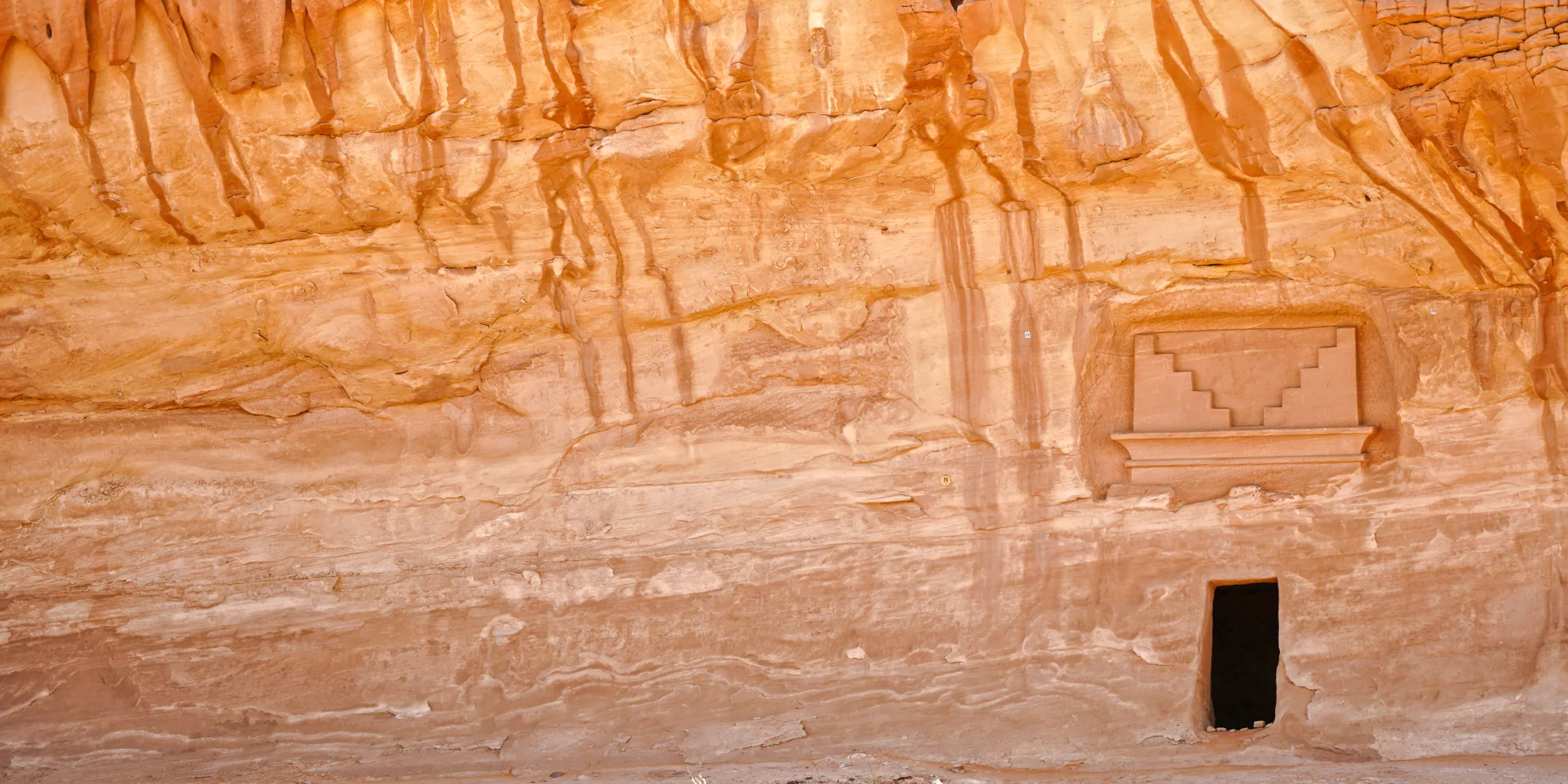 Ancient rock-carved facade at Hegra, AlUla, Medina, showcasing Nabatean architecture.