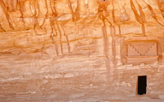 Ancient rock-carved facade at Hegra, AlUla, Medina, showcasing Nabatean architecture.
