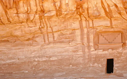 Ancient rock-carved facade at Hegra, AlUla, Medina, showcasing Nabatean architecture.