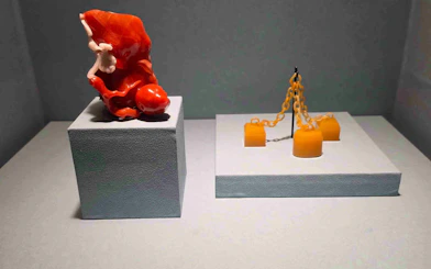 Exhibit of red coral sculpture and yellow chain artifact at National Palace Museum.