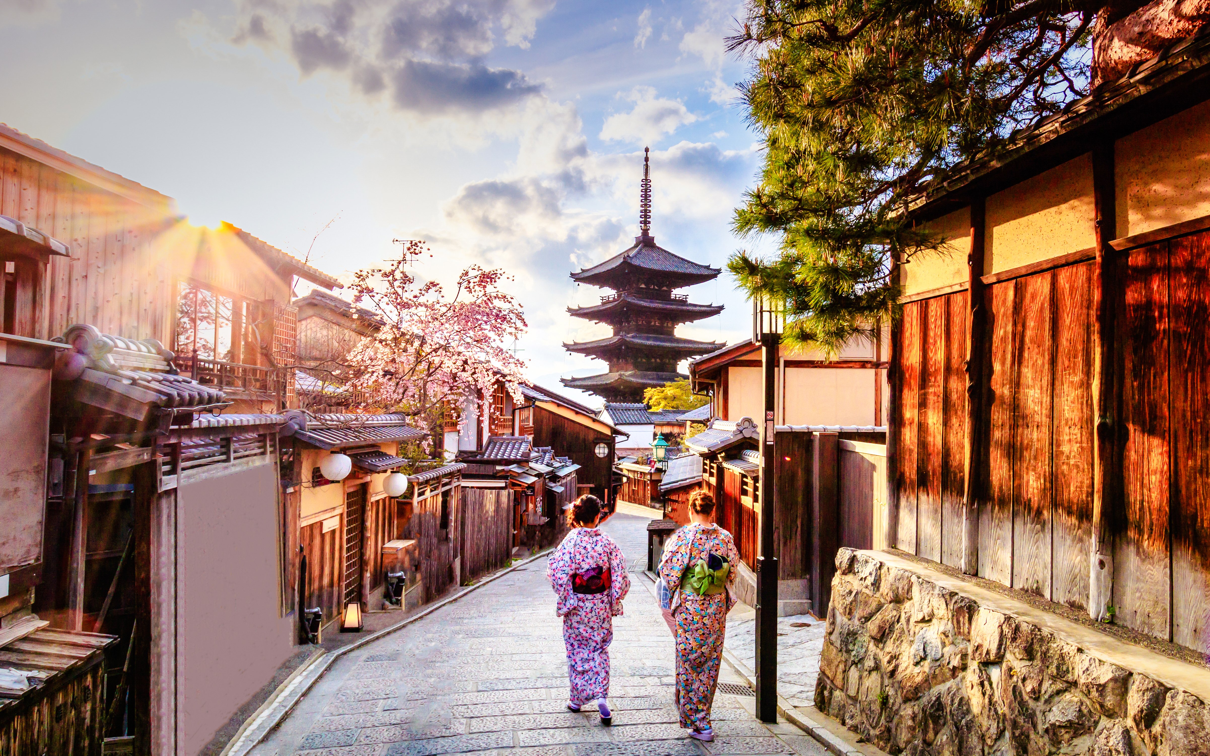 Two people in traditional attire walking towards Yasaka Pagoda in Kyoto, Japan.