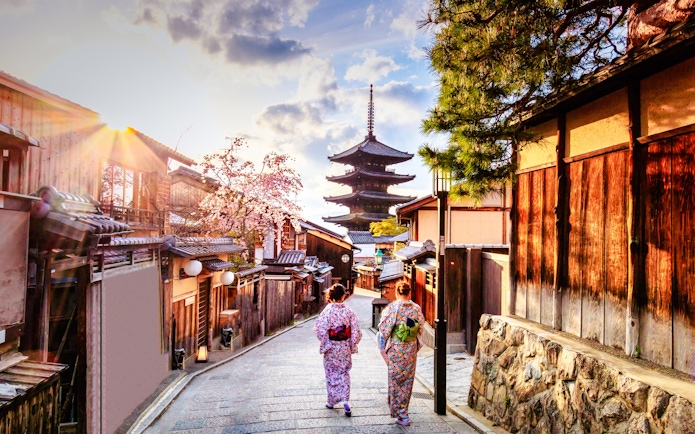 Two people in traditional attire walking towards Yasaka Pagoda in Kyoto, Japan.