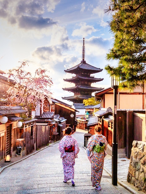 Two people in traditional attire walking towards Yasaka Pagoda in Kyoto, Japan.