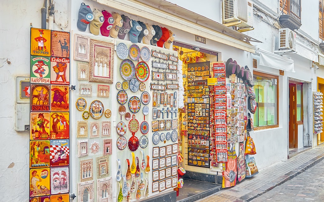 Handicraft store displays colorful ceramics and souvenirs on Calle Deanes, Cordoba, Spain.