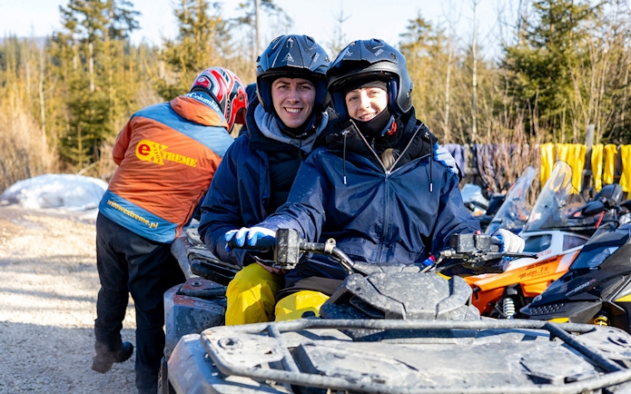 Guests on a quad bike during adventure tour in Zakopane forest.