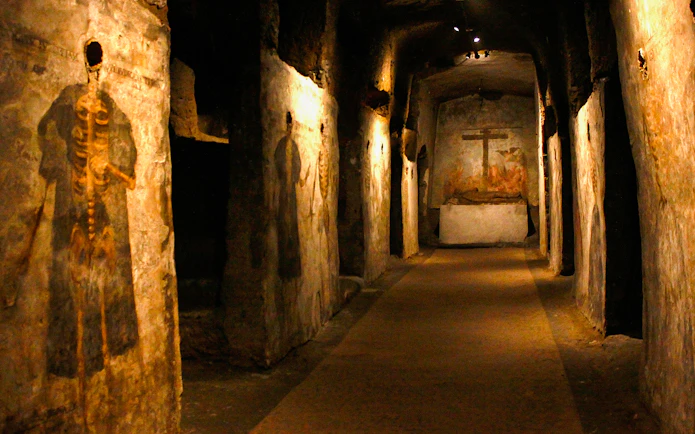 Visitors touring the Catacombs of San Gaudioso, Naples, Italy, with ancient frescoes.