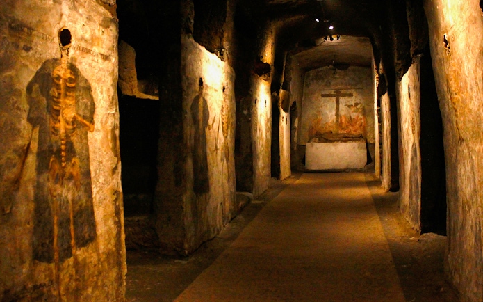 Visitors touring the Catacombs of San Gaudioso, Naples, Italy, with ancient frescoes.