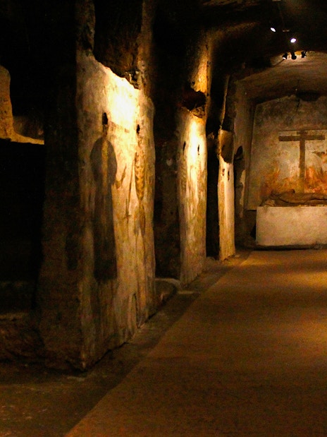 Visitors touring the Catacombs of San Gaudioso, Naples, Italy, with ancient frescoes.