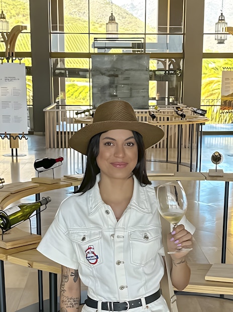 Tourist enjoying wine tasting at a vineyard in Chile with scenic views.