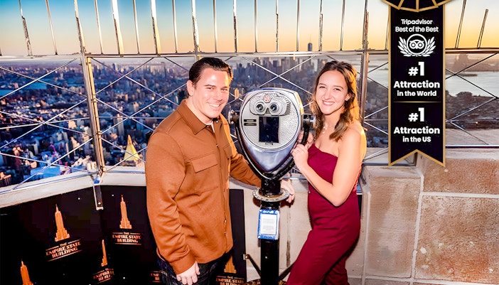 Tourists using a viewfinder to enjoy the cityscape from the Empire State Building, New York.