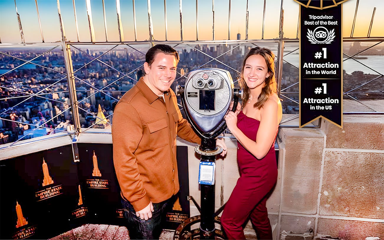 Tourists using a viewfinder to enjoy the cityscape from the Empire State Building, New York.