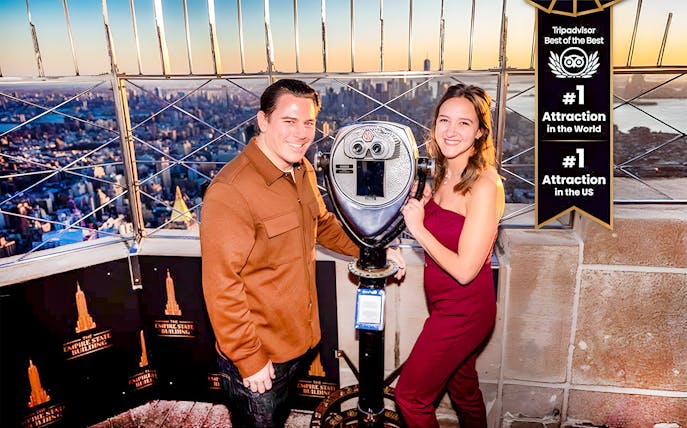 Tourists using a viewfinder to enjoy the cityscape from the Empire State Building, New York.